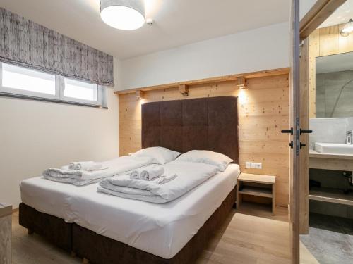 1 dormitorio con 1 cama con sábanas blancas y lavamanos en Apart33 Top 2-10, en Haus im Ennstal