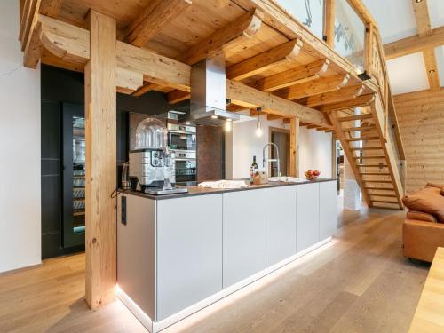 a kitchen with white cabinets and wooden ceilings at Apart33 Top 1-33 Penthouse in Haus im Ennstal