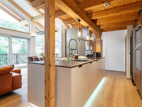 a kitchen with a large island in a room with wooden ceilings at Apart33 Top 1-33 Penthouse in Haus im Ennstal