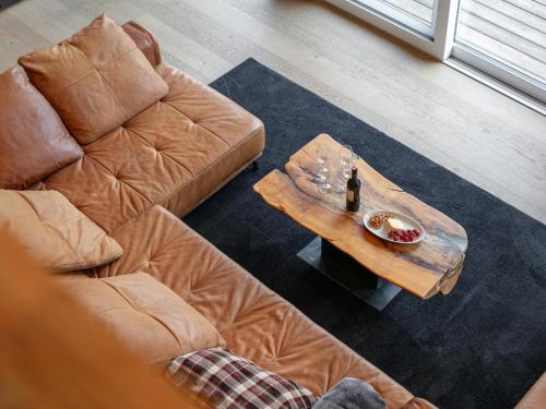 a living room with a couch and a table with a bottle of wine at Apart33 Top 1-33 Penthouse in Haus im Ennstal
