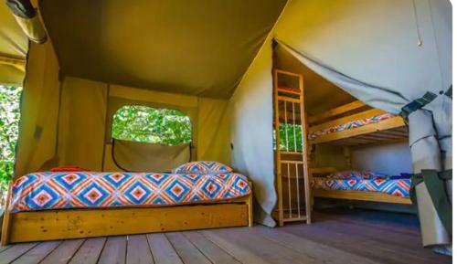 une chambre avec deux lits dans une tente dans l'établissement Lodge Bois et Toile avec Vue, à Doussard