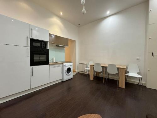 une pièce avec une cuisine avec une table et un réfrigérateur dans l'établissement Awesome 2BR 5 min to Arc de Triomphe, à Paris