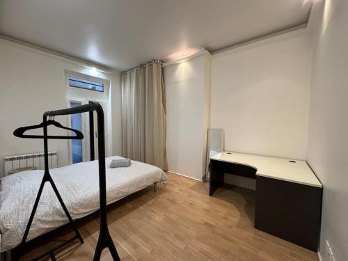 une chambre avec un lit et un bureau dans l'établissement Awesome 2BR 5 min to Arc de Triomphe, à Paris