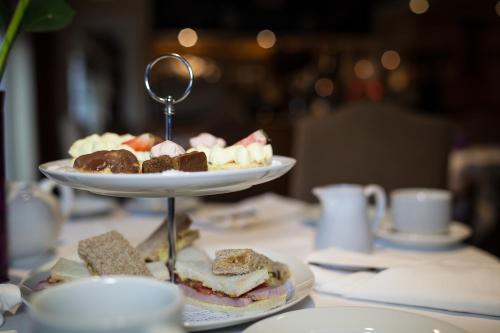 a table with a plate of sandwiches and desserts at Warren Lodge in Shepperton