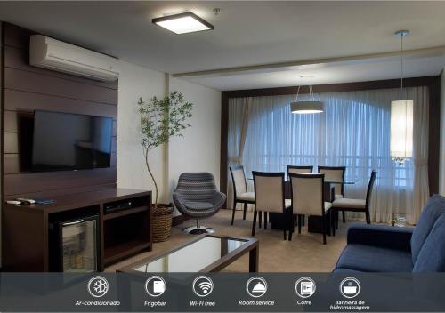 a living room with a tv and a dining room at Master Gramado Hotel - Espaço Kids Incrível in Gramado