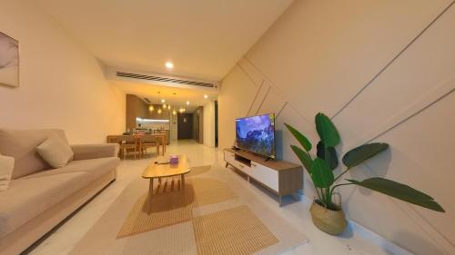a living room with a couch and a tv at Eaton Residence KLCC - KL SUITE in Kuala Lumpur