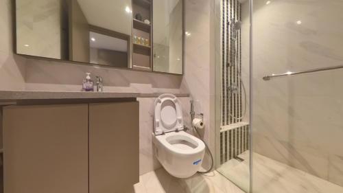 a bathroom with a white toilet and a shower at Eaton Residence KLCC - KL SUITE in Kuala Lumpur