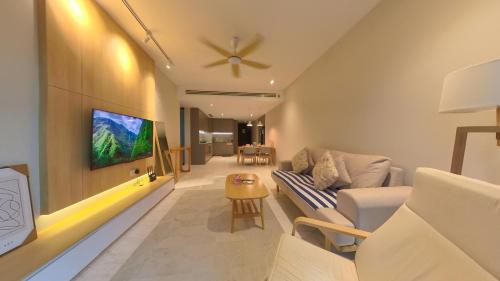 a living room with a couch and a tv on a wall at Eaton Residence KLCC - KL SUITE in Kuala Lumpur