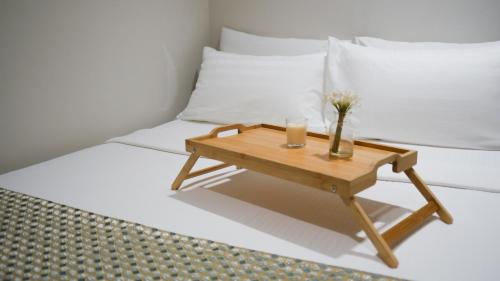 a wooden table with a vase on a bed at Eaton Residence KLCC - KL SUITE in Kuala Lumpur