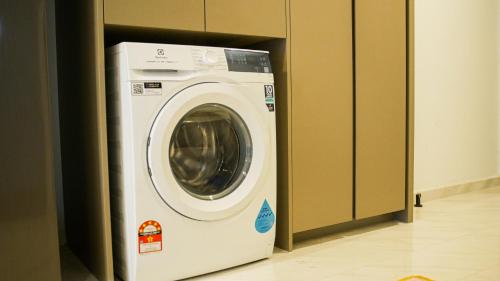a white washing machine in a door in a room at Eaton Residence KLCC - KL SUITE in Kuala Lumpur