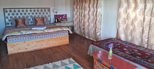 a bedroom with a bed and a wooden floor at Skara Shangara Homestay in Leh