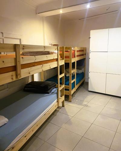 a room with two bunk beds and a refrigerator at Alberg Els Andes in Andorra la Vella