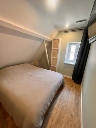 a small bedroom with a bed and a window at La Mignardise du Château in Lichtenberg