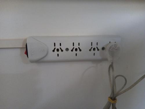 eine weiße Steckdose an einer weißen Wand mit einem Kabel in der Unterkunft Urquiza - Habitación para turistas in Cordoba