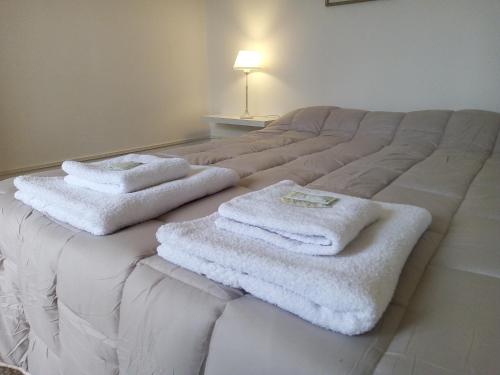 a bed with white towels on top of it at Urquiza - Habitación para turistas in Córdoba