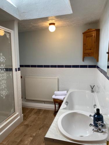 a bathroom with a sink and a bath tub at Home outside Abergavenny in Llanfaenor