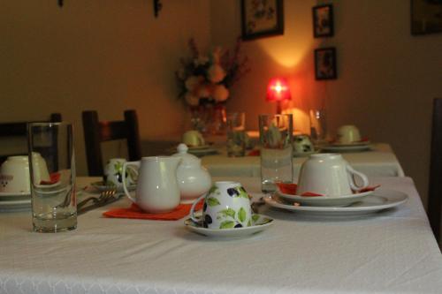 a table with a white table cloth with plates and cups at Casa Deimar in Matelica