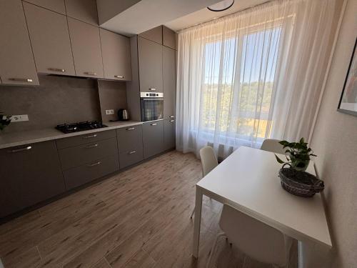 a kitchen with a white table and a large window at Milescu Residence 2 in Chişinău