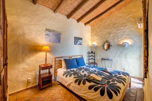 a bedroom with a bed and a table with a lamp at Luazinha - Lovingly renovated Fisherman's cottage in Tavira