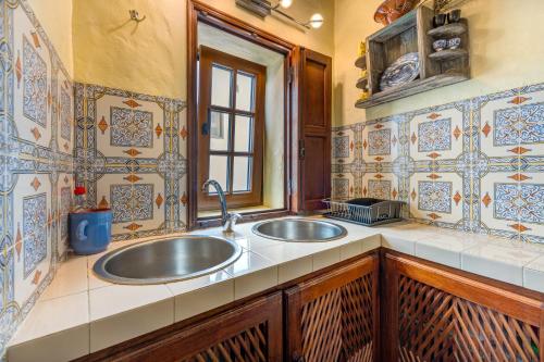 a kitchen with two sinks and a window at Luazinha - Lovingly renovated Fisherman's cottage in Tavira