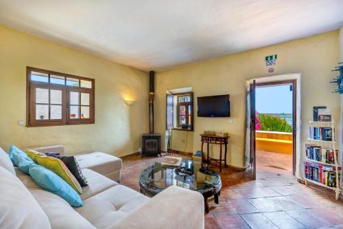 a living room with a white couch and a glass table at Luazinha - Lovingly renovated Fisherman's cottage in Tavira