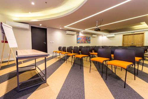 a conference room with chairs and a podium at Hotel Cassino Tower São José do Rio Preto by Nacional Inn in Sao Jose do Rio Preto