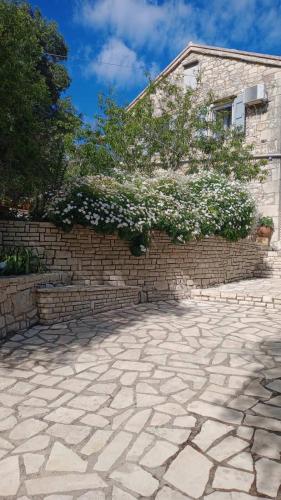a brick wall with a tree and white flowers at Villa Makris in Zenempisátika