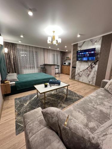 a living room with a couch and a tv at Гоголя 41 in Karagandy