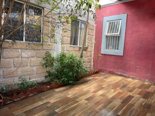 a red house with a wooden floor and a red wall at Hermosa casa con dos habitaciones y dos baños in Cerro Gordo