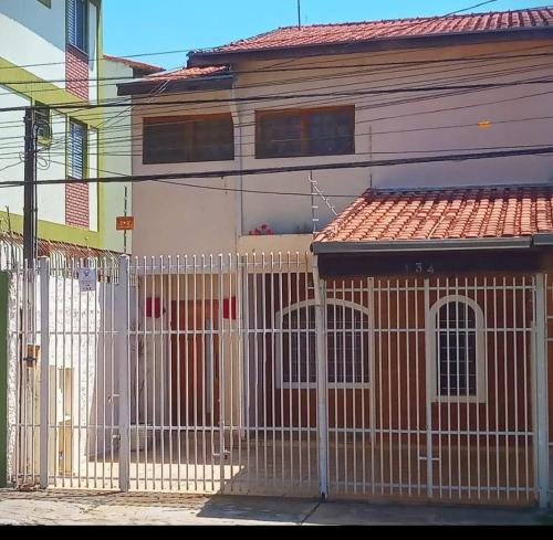 a white fence in front of a house at STUDIO 01 Suite externa pirvativa in São José dos Campos