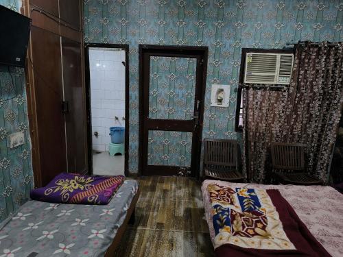 a room with a bed and a door and a bed sidx sidx sidx at HOTEL JOGI GUEST HOUSE welcome all families, friends, groups, couples, singles fully Airconditioner, attach washrooms, lift, wifi, 24 hours room service, power backup in Amritsar