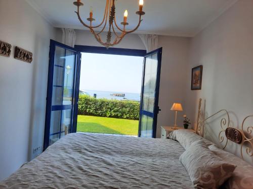 a bedroom with a bed and a large window at El Pinedo AZUL 3 dormitorios in Noja