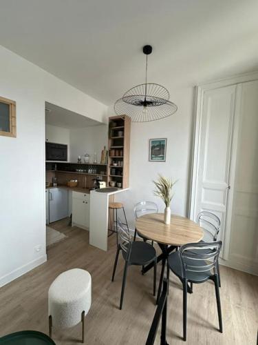 une salle à manger et une cuisine avec une table et des chaises dans l'établissement La Belle brise, à Granville