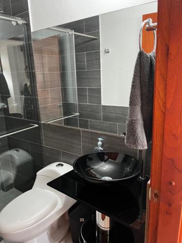 baño con lavabo negro y aseo en Casa familiar RS, en Villa de Leyva