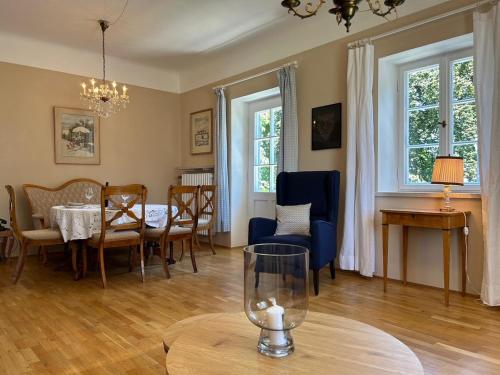 a living room with a table and a dining room at Ferienwohnung Villa Victoria mit grandiosem Seeblick und Gartennutzung in Jugendstil Villa in Gstadt am Chiemsee