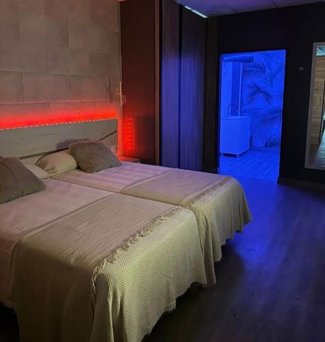a bedroom with two beds in a room with blue lights at Guadiana Loft Experience Nadra in Badajoz