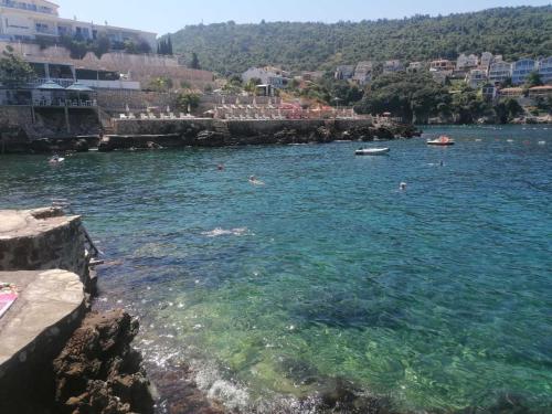 a large body of water with people swimming in it at APARTMANI LUX SEA in Utjeha