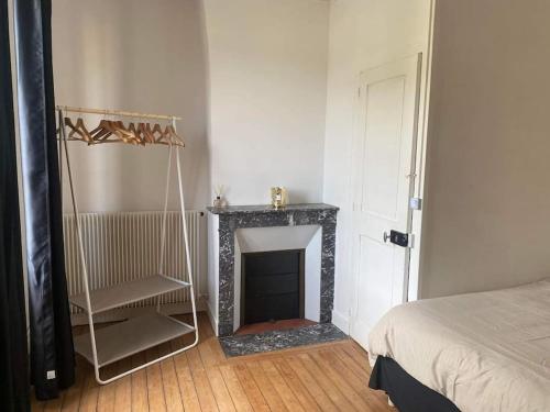 une chambre avec une cheminée et un lit et une chambre avec un lit gmaxwell gmaxwell dans l'établissement Comme une évidence, à Fécamp