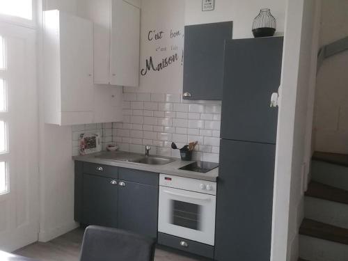La cuisine est équipée d'un évier et d'un réfrigérateur noir. dans l'établissement Comme une évidence, à Fécamp
