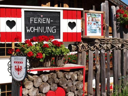 a sign for a flower shop with red flowers at Alpenferienwohnung Strickner in Neustift im Stubaital