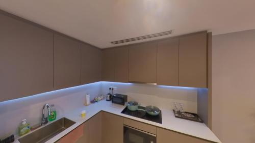 a kitchen with brown cabinets and a blue counter top at Eaton Residence KLCC - KL SUITE in Kuala Lumpur