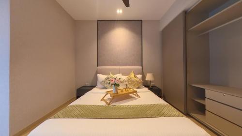 a bedroom with a bed with a vase of flowers on it at Eaton Residence KLCC - KL SUITE in Kuala Lumpur