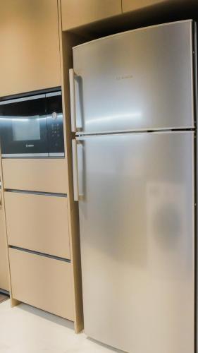 a stainless steel refrigerator in a kitchen next to a microwave at Eaton Residence KLCC - KL SUITE in Kuala Lumpur