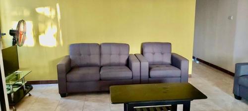 a living room with two chairs and a couch at Emam apartments in Grand Baie