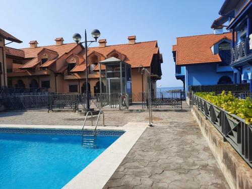 a swimming pool in front of a house at El Pinedo AZUL 3 dormitorios in Noja