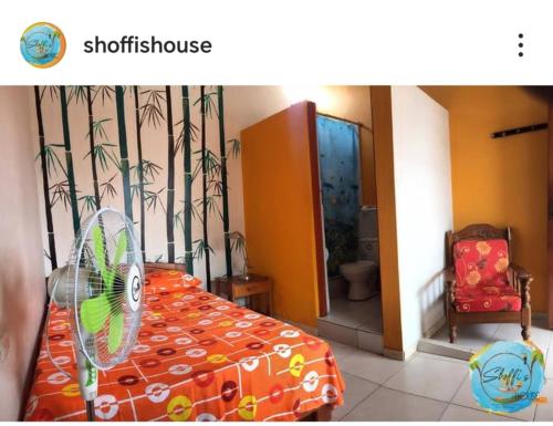 a bedroom with a bed with a fan in it at Shoffi's House Backpackers in Tarapoto