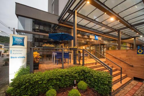 a restaurant with a table and chairs in a building at ibis budget Blumenau in Blumenau