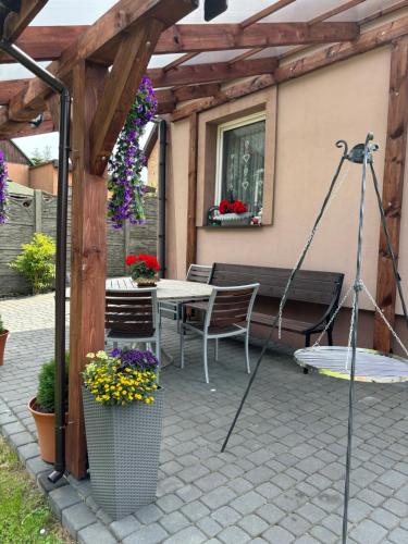 a patio with a bench and a table with flowers at Agroturystyka ‚U Misia’ in Krzywopłoty