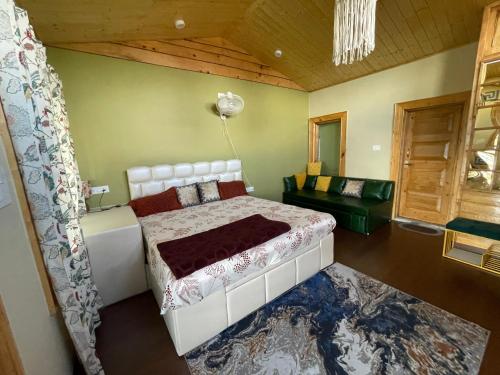 a bedroom with a white bed and a couch at Vacay Datcha 1 double room in Kūd
