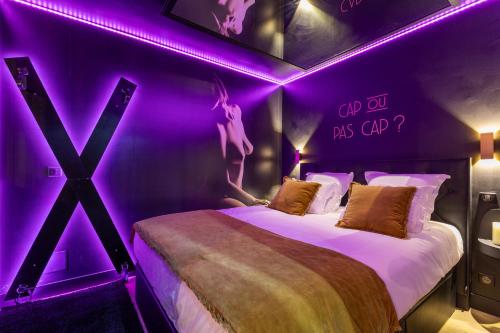 a room with two beds with purple lights at Villa Close Port Nature in Cap d'Agde